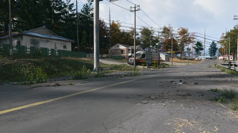 Quiet suburban road lined with houses, utility poles, autumn trees, and an abandoned ambulance.
