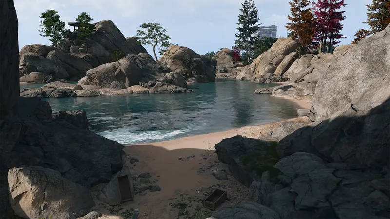 Secluded sandy cove surrounded by massive rocks, calm water, and scattered trees.